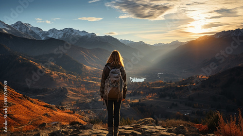 Isolated young lady traveler hiking through a mountain in a sunny day and looking at the mountain range landscape view  photo