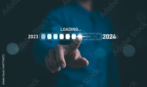 Businessman touch on loading progress from 2023 to 2024,Planning and challenge strategy in new year 2024 Concept. New business startup in 2024. New year 2024 is loading, calendar date, end of the year photo