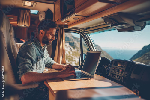 man handsome using laptop in the camper car in the holiday