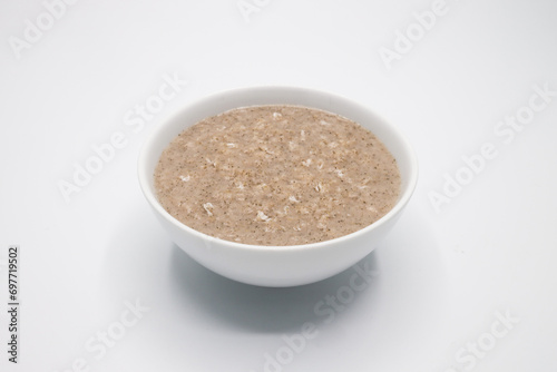 Bowl with tasty oatmeal on white Background