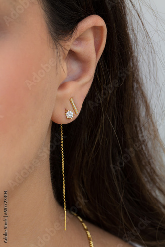 Woman wearing beautiful dangly and stud earrings with zirconia. photo