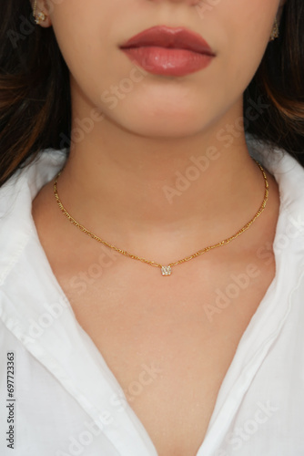 Young woman wearing a Figaro Chain Necklace containing a square zircon.