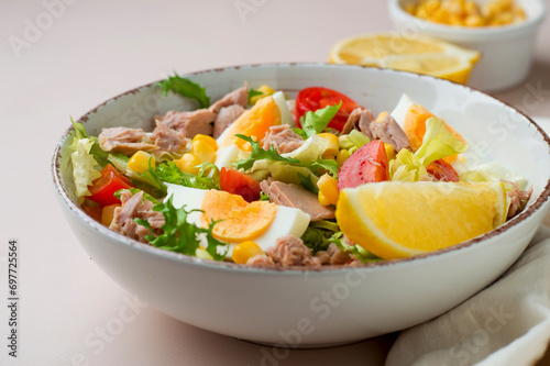 Fresh salad of tuna, egg, lettuce, cherry tomatoes, corn and lemon. Dietary, complete bowl of salad.