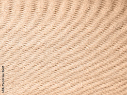 Factory textile fabric material surface peach light colored background with thread © daniiD