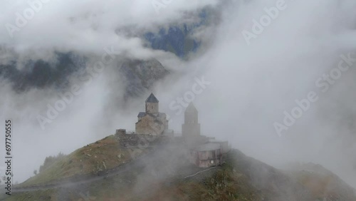 Gergeti Trinity Church in clouds after rain near Village Of Gergeti and Kazbek mountain In Georgia. photo