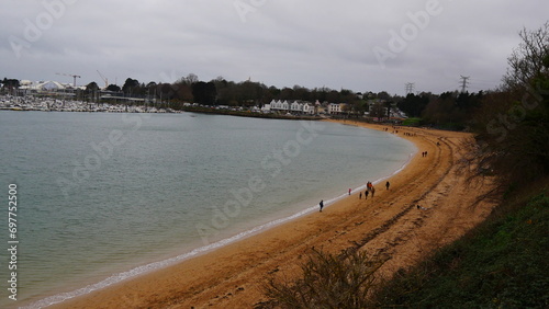 Promenade à la plage de la rade de Brest, sous un temps pluvieux, ciel gris, beaucoup de vent, détente de famille et de bien-être, avec installation côtière et de la végétation maritime © Nicolas Vignot