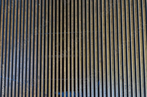 Abstract Background of a Steel Grating with Tones of Gold and Black.