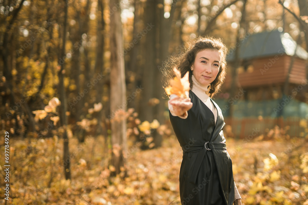 Attractive young woman walking in autumn park, happy mood and fashion style trend and curly long brown hair. Fall season and pretty female portrait copy space. Millennial generation concept Attractive young woman walking in autumn park, happy mood and fashion style trend and curly long brown hair. Fall season and pretty female portrait copy space. Millennial generation concept