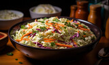 Freshly made creamy coleslaw salad in a teal bowl, a classic side dish garnished with shredded carrots and purple cabbage on a dark table