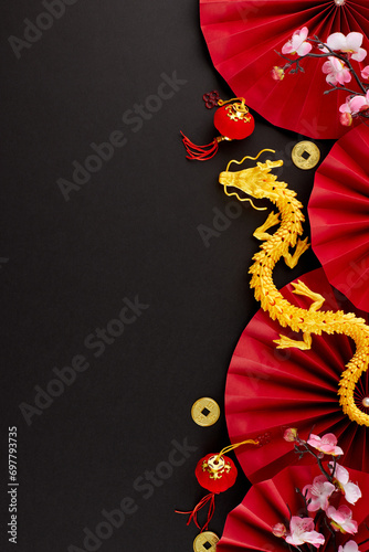 Cheers to Chinese New Year 2024. Top view vertical photo of gold dragon, red featuring fans, auspicious coins, decorative elements, sakura on black background with promo area