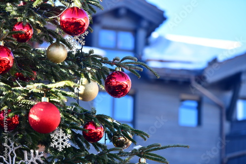 Decorated Christmas tree in front of a chalet 