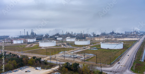 Aerial view of a Fuel Refinery in Port Arthur Texas, located on the Gulf Coast,  with fuel storage, pipelines, steam rising from tall chimneys and an overcast sky above. photo