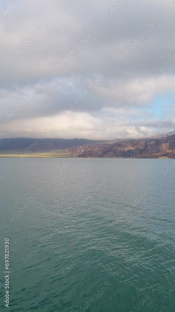 Flying over the lake. Sandy mountains and blue cloudy sky. Boat view. Vertical Video Flying over the lake. Sandy mountains and blue cloudy sky. Boat view. Vertical Video