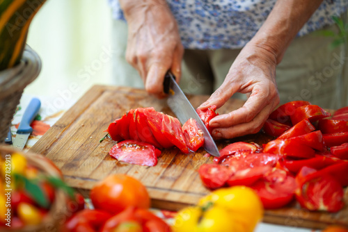 Woman Hands Preparing Fresh Tomatoes From Domestic Garden into Tomato Sauce photo