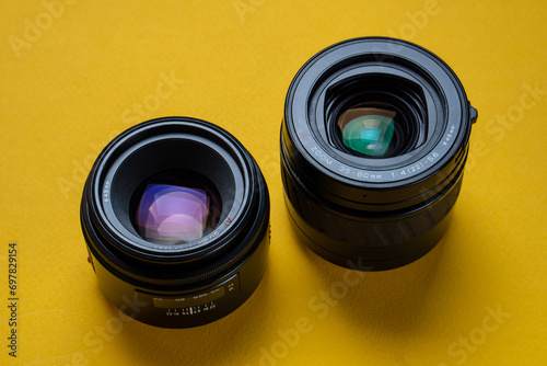 Camera lenses on a yellow background. Optical devices for image focusing.