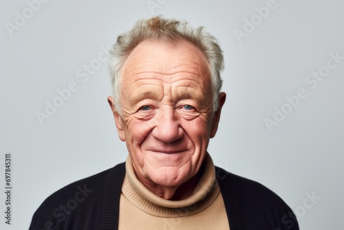 Portrait of a happy senior man with grey hair, isolated on grey background