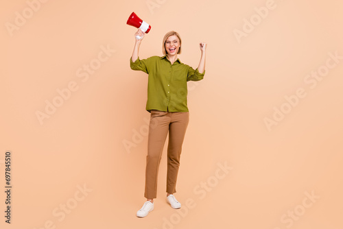 Full size photo of satisfied woman dressed green shirt in glasses hold megaphone celebrate black friday isolated on beige color background