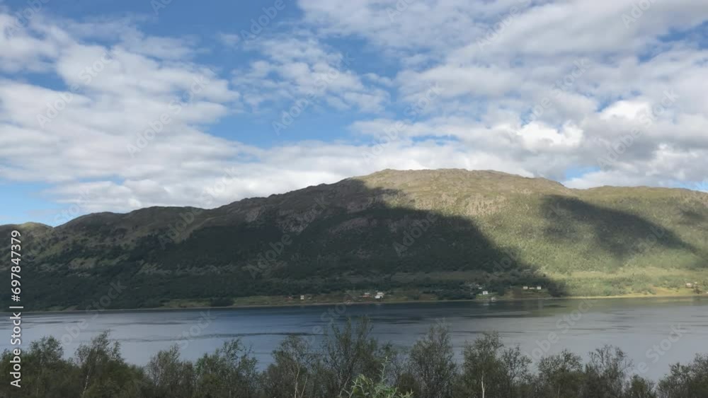 The white clouds in the sky in Norway with the view of the fjord and the terrain. Camera moves left. Timelapse Mighty Nature. The white clouds in the sky in Norway with the view of the fjord and the terrain. Camera moves left. Timelapse Mighty Nature.
