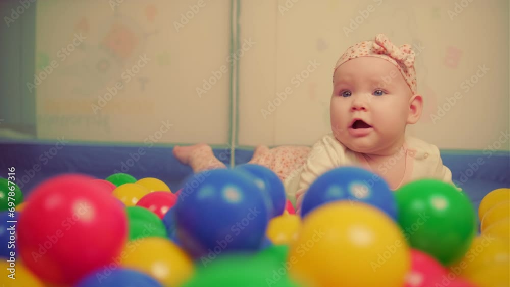Cute baby girl playing with colorful balls in kindergarten. Cute baby girl playing with colorful balls in kindergarten.