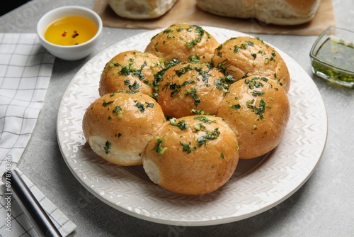 Traditional pampushka buns with garlic and herbs on grey table photo