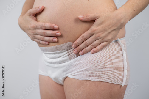 Close-up of a woman's belly after a caesarean section. A mother who recently gave birth.