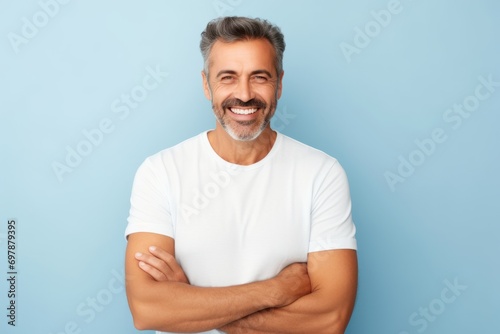 Handsome middle-aged man with white t-shirt on blue background photo