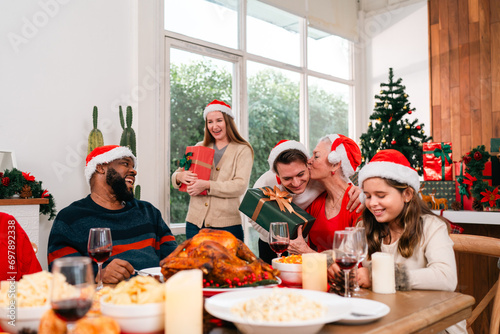 Happy multi-generation family gathered at home on Christmas day, exchanging Christmas presents and enjoying spending time together during winter holiday season