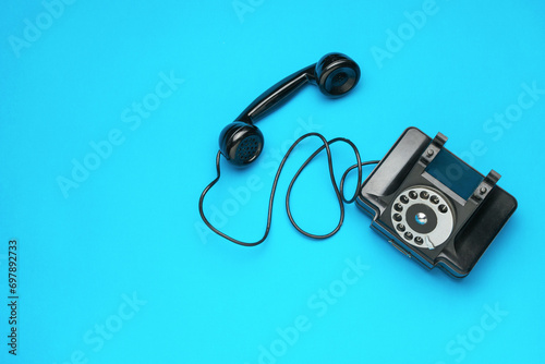 Top view of an antique telephone on a blue background.