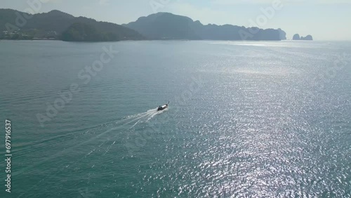 A video from a drone capturing the fast-moving ship sailing in the turquoise blue sea during midday.4k