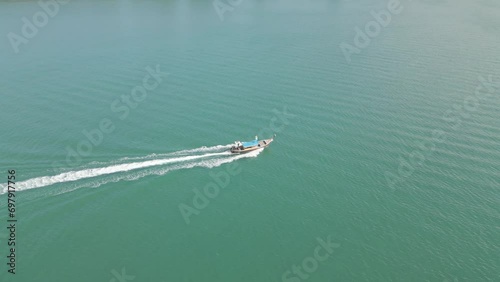 A video from a drone capturing the fast-moving ship sailing in the turquoise blue sea during midday.4k