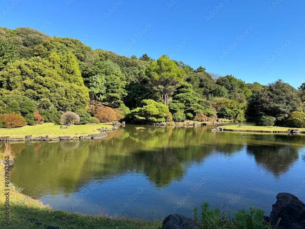 Japanese garden on a sunny day, the surface of the lake reflecting autumn trees