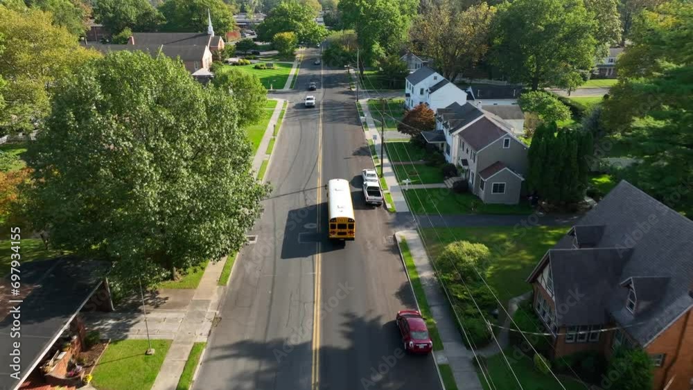 Yellow school bus driving on small town USA street. Aerial tracking shot. Yellow school bus driving on small town USA street. Aerial tracking shot.