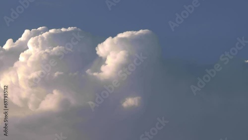 Billowing clouds, cumulonembus growing a storm at the sunset photo