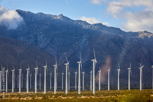 Large wind turbines converting wind into energy located in the desert near Palm Springs California USA
