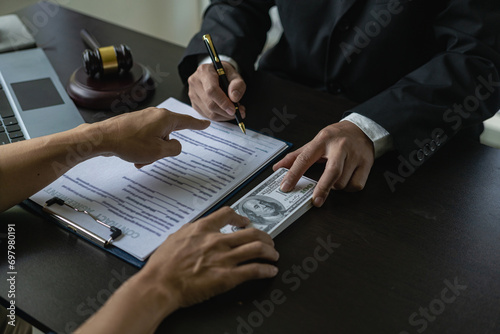 Bribery and corruption, businessman or lawyer is negotiating a deal where the dollar is accepted as a bribe in corruption, anti-bribery concept. Close-up image