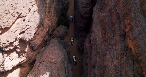 Top View Of Cars Driving Amidst Vast Plateau In Tassili N'Ajjer National Park In Southeastern Algeria. Aerial Shot