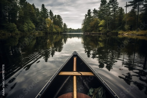 Tranquil canoeing scene on a calm forest lake with reflection of trees on water.