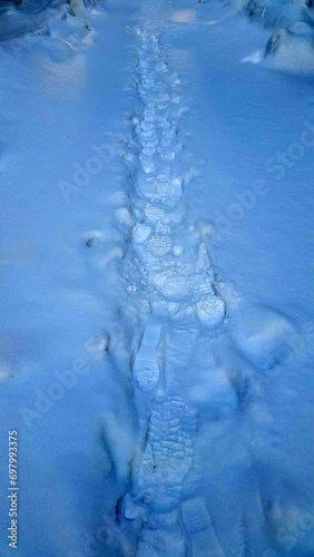 Footprints in the snow. Snowy surface with human traces. Winter landscape