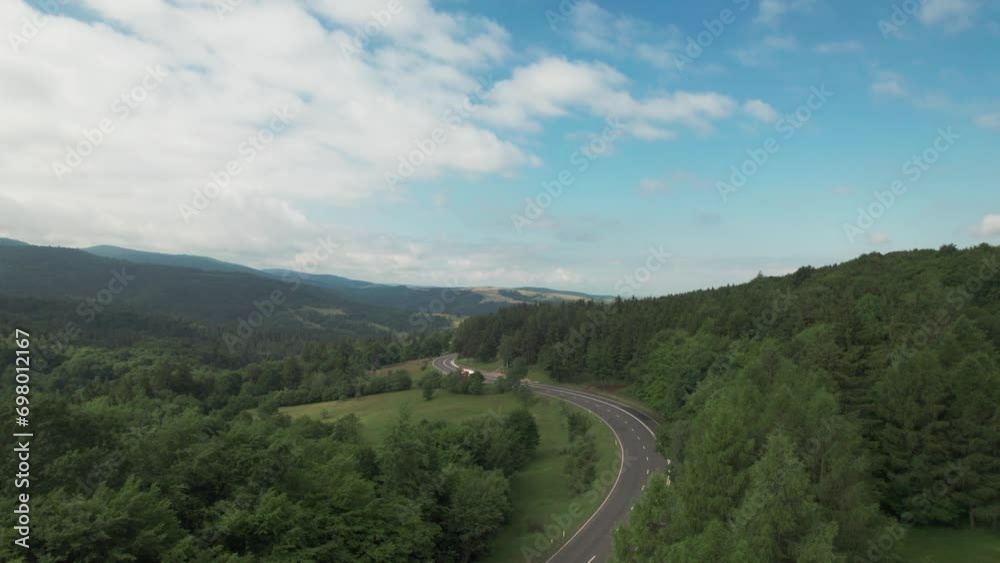 Aerial drone view of nature in Romania. Carpathian mountains, road, yellowed hill covered with forest Aerial drone view of nature in Romania. Carpathian mountains, road, yellowed hill covered with forest