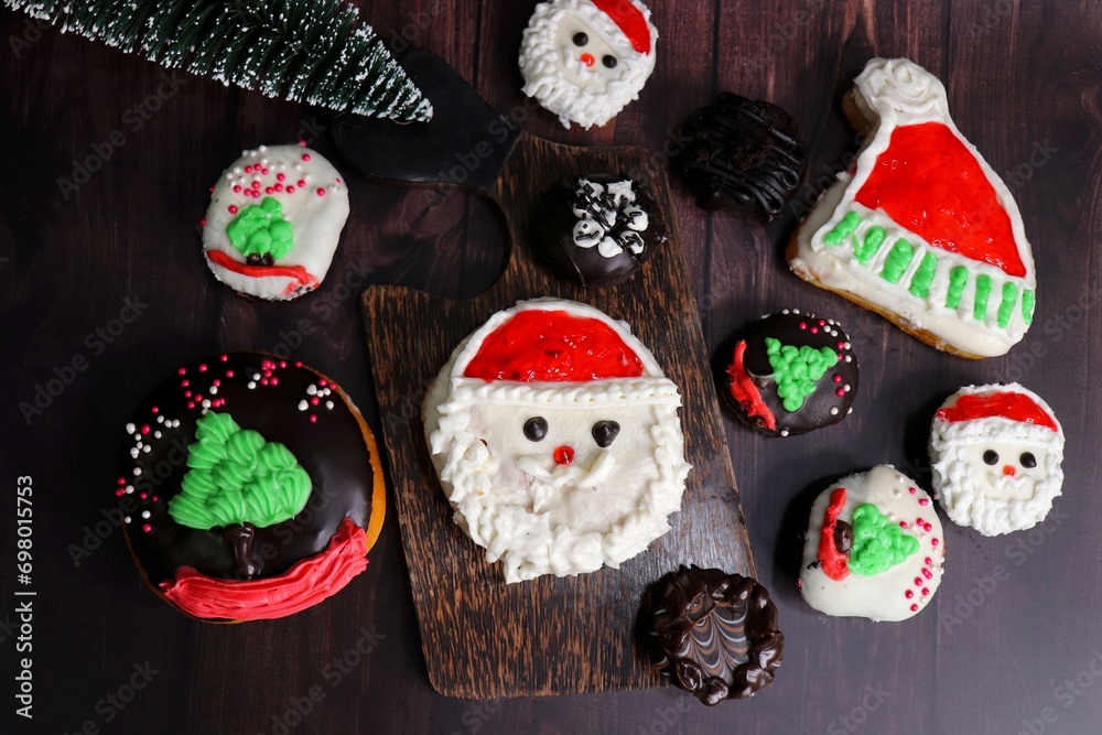 Homemade Glazed Christmas Donuts. Assorted Christmas design donuts include reindeer, Santa Claus, Xmas tree, and chocolate. festival background. copy space. festive or holiday concept.