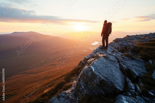 Lone Hiker's Enchanting Sunrise View Of The Vast Valley From The Mountain Edge © Anastasiia