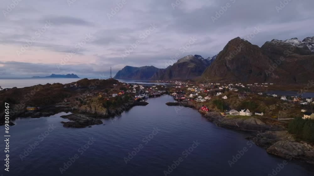 aerial smooth cinematic view of sorvagen village bay with red fishing rorbu cabins and boats on the shore on lofoten islands in norway during sunrise aerial smooth cinematic view of sorvagen village bay with red fishing rorbu cabins and boats on the shore on lofoten islands in norway during sunrise