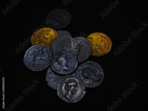 Roman gold and silver coins on a black background photo