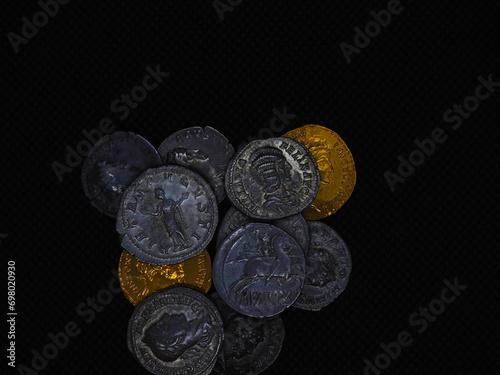 Roman gold and silver coins on a black background photo