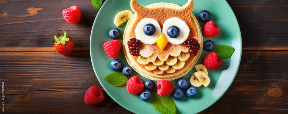 Creative owl pancakes on plate. Pancake for kids with forest fruits.