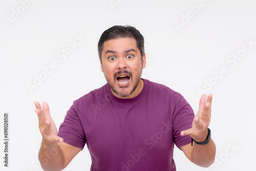 A stubborn middle aged man looking annoyed while trying to explain his point of view. Wearing a purple waffle shirt. Isolated on a white background.