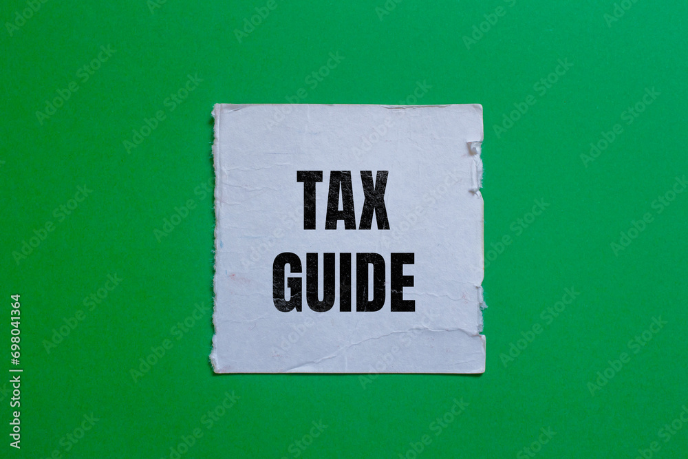 Tax guide lettering on ripped paper. Business concept photo. Tax guide lettering on ripped paper. Business concept photo.