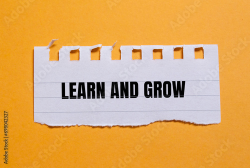 Learn and grow lettering on ripped paper. Conceptual photo.