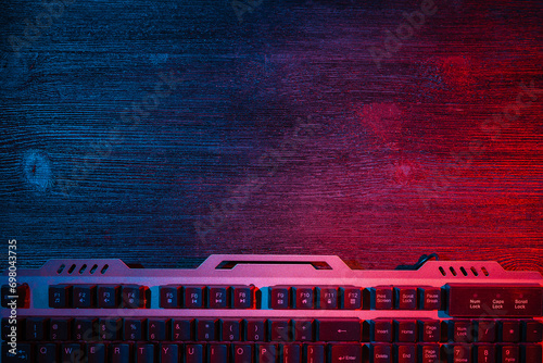 Modern metal computer keyboard on the flat lay desk table background with copy space. Cybersport.