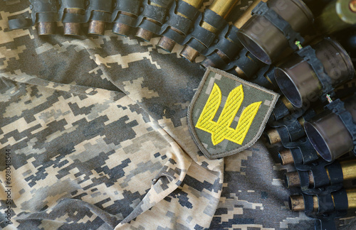 Ukrainian army symbol on machine gun belt lies on ukrainian pixeled military camouflage close up photo